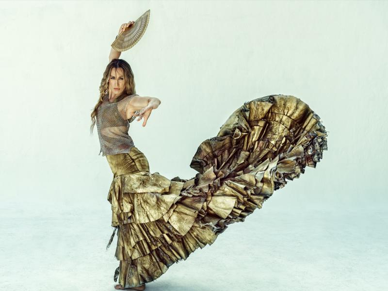 Woman flamenco dancer wearing gold dress.