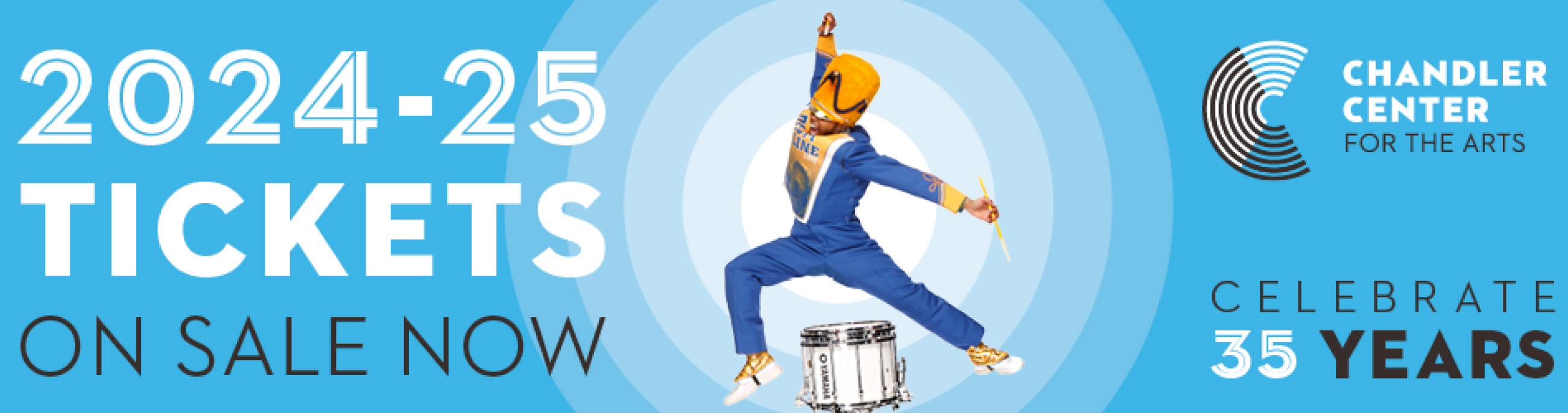 A drum major is mid-jump in the middle of a blue background