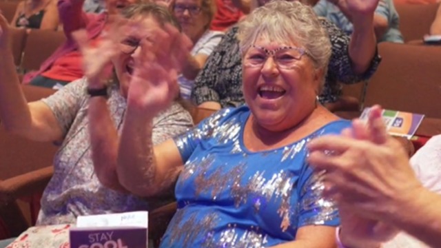 Group of women sitting in the CCA theatre, clapping and enjoying the Free Summer Concert Series